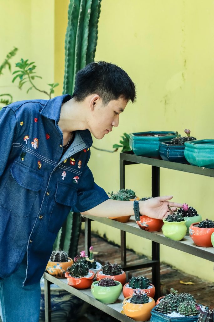 a man pointing at a plant